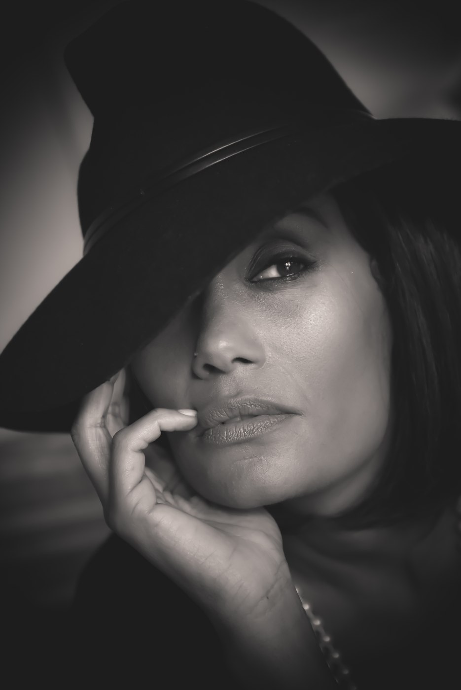 Portrait en noir et blanc d’une femme portant un grand chapeau.