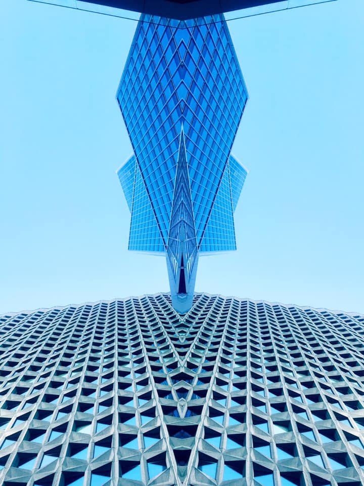 Perspective verticale d’une façade de verre sur fond de ciel bleu.
