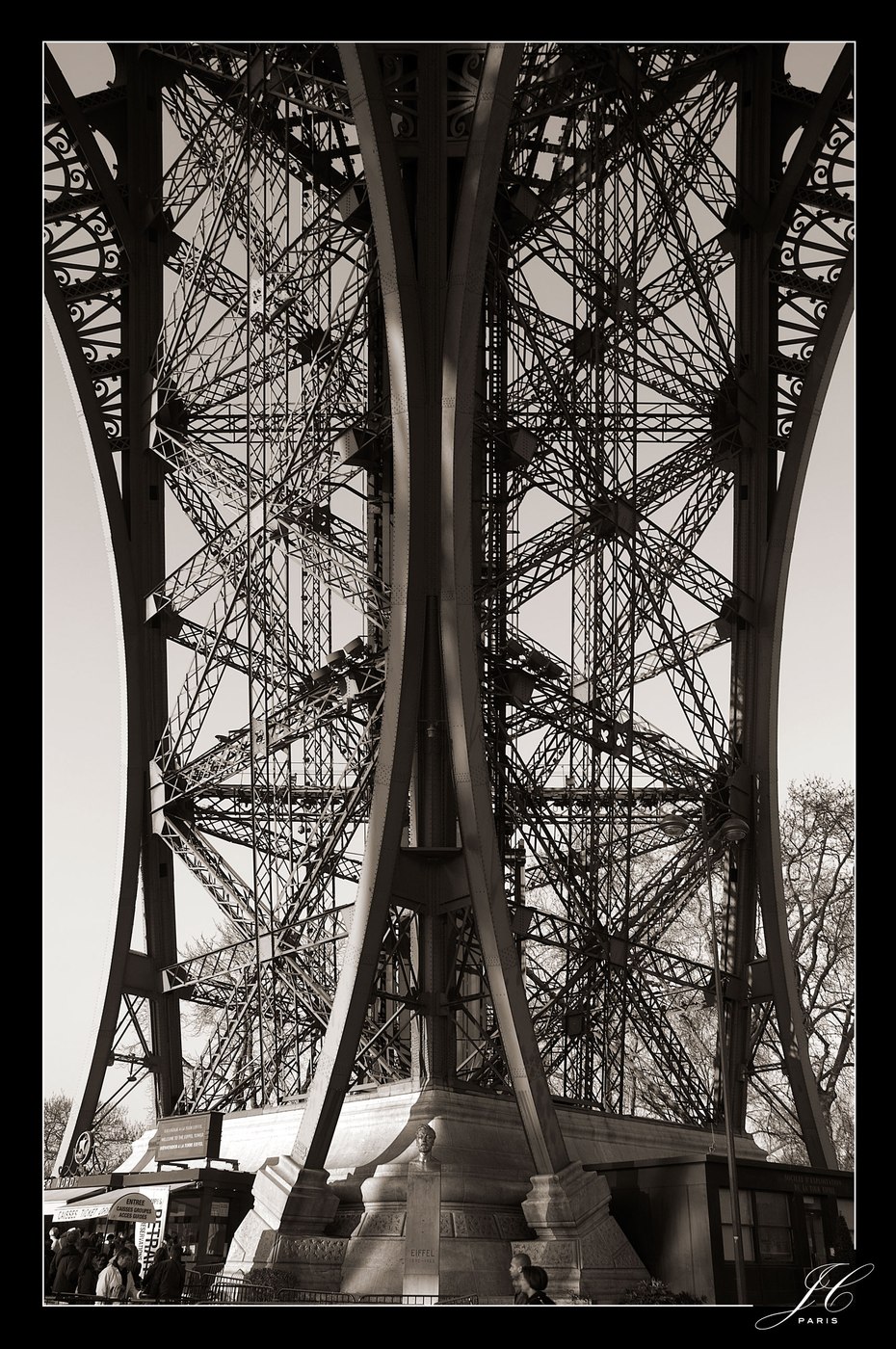 Structure métallique de la tour Eiffel photographiée en noir et blanc.