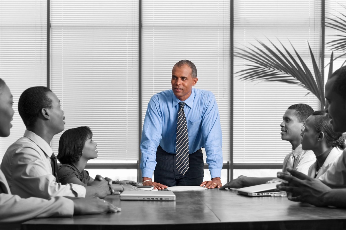Réunion autour d’une table, avec une chemise bleue mise en couleur.