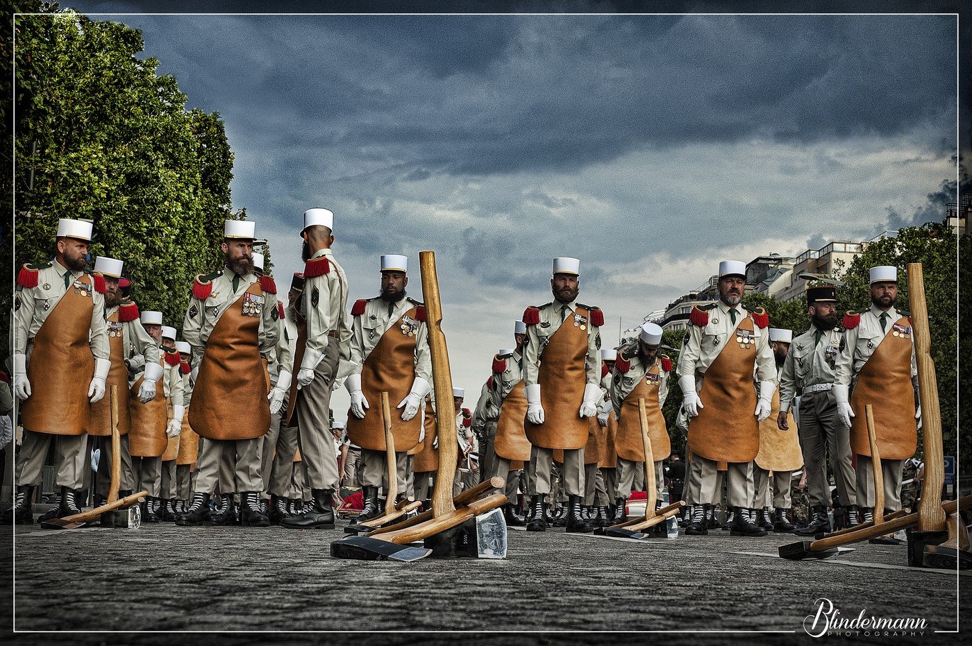 Cavaliers en uniforme alignés sous un ciel sombre.